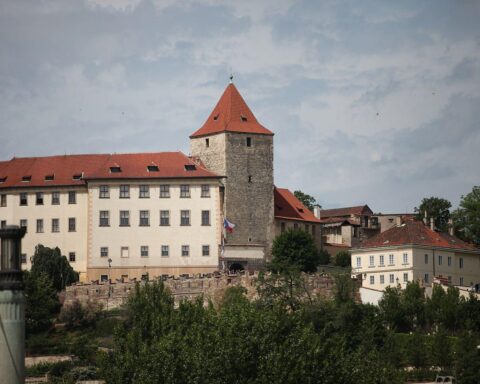 Prager Burg mit Warnhinweis zu Hepatitis A und Hygienemaßnahmen im Vordergrund.