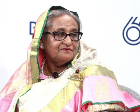 Porträt von Sheikh Hasina Wajed, mit Symbolen für Protest und Unruhen im Hintergrund.