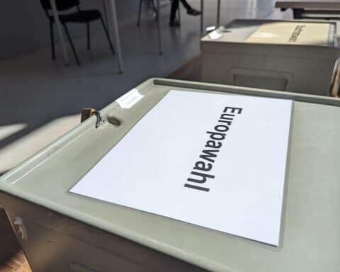 Wahllokal mit Wählern, Symbol für Europawahlen und politische Diskussionen über Parteieinfluss.