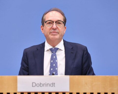Alexander Dobrindt auf dem Sicherheitsgipfel, gestikulierend, im Hintergrund sicherheitspolitische Themen.