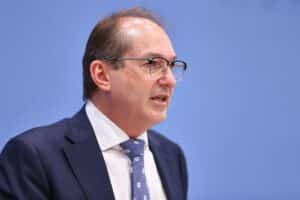 Alexander Dobrindt spricht über Cyberabwehr, umgeben von Politikern, mit Kritiken im Hintergrund.