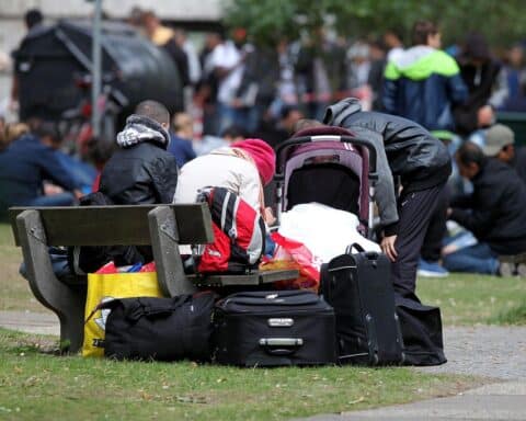 Flüchtlinge an Aufnahmestelle, symbolisiert Europa und aktuelle Asylreformen sowie politische Debatten.