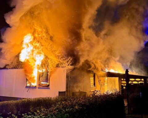 Brennendes Einfamilienhaus mit Feuerwehr im Einsatz, Bewohner sicher, Feuerwehrmann verletzt.