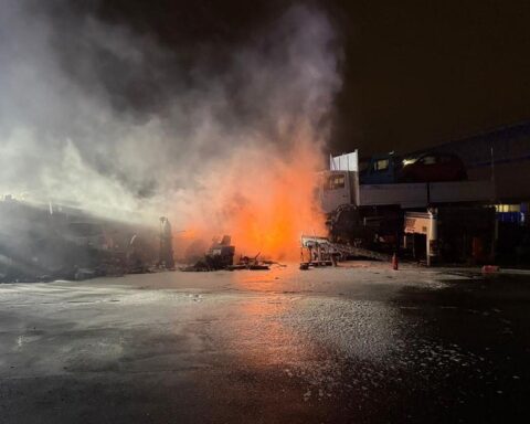 Brennende LKW-Reifen und Schrott in einem Autoverwertungsbetrieb, Feuerwehr im Einsatz.