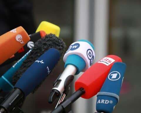 Mikrofone von Journalisten, symbolisieren Pressefreiheit und den Protest gegen Visa-Beschränkungen.