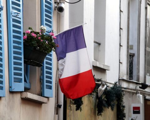 Nicolas Sarkozy verlässt das Gefängnis; französische Fahne symbolisiert nationale Bedeutung des Ereignisses.