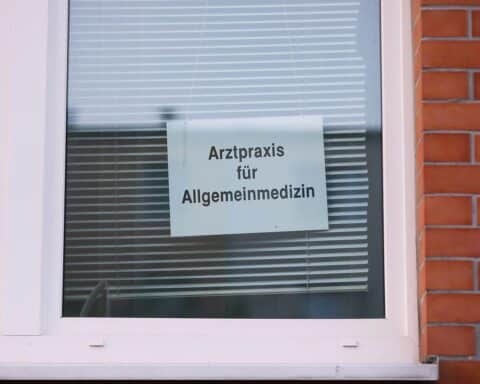 Arztpraxis mit medizinischem Personal, symbolisiert Versorgung und Diskussion über Praxisgebühren in Deutschland.