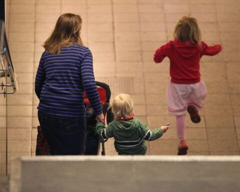 Mutter mit zwei Kindern zeigt die Auswirkungen von Armut auf Familien in Deutschland.