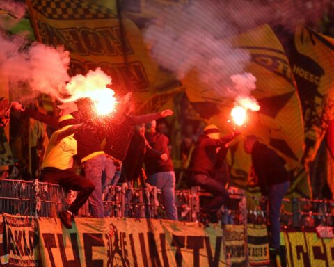 Fans zünden Pyrotechnik im Stadion, symbolisiert die Diskussion über Gewalt im Fußball.