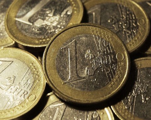 Euromünzen mit einem Hintergrund, der Finanzthemen und Infrastrukturinvestitionen symbolisiert.