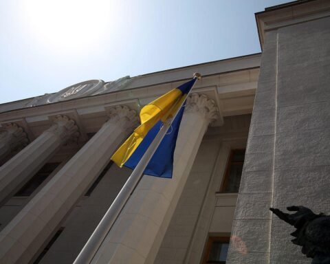 Ukrainische Flagge vor Parlament, symbolisiert Korruptionsskandal und politische Turbulenzen in Kiew.