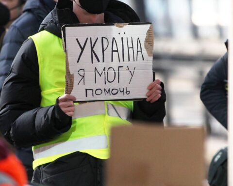 Gruppierung von Flüchtlingen, die aus der Ukraine in Deutschland ankommen, mit erschöpften Gesichtsausdrücken.