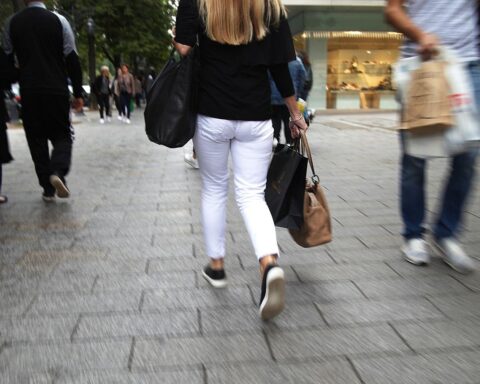 Passantin in Düsseldorfer Einkaufsstraße, die Schwierigkeiten des Einzelhandels spiegelt.