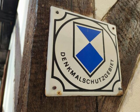 Bild eines historischen Denkmals, das renoviert wird, mit Handwerkern und Materialien zur Sanierung.