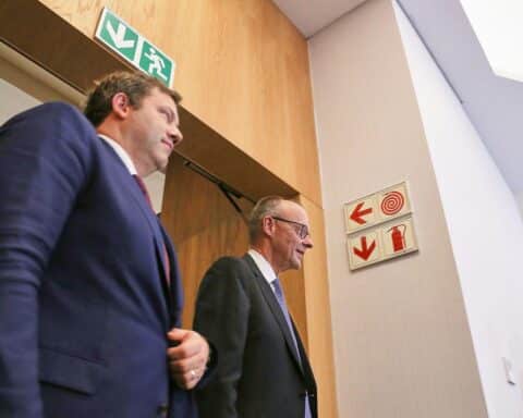 Lars Klingbeil und Friedrich Merz stehen während einer politischen Diskussion in Berlin zusammen.