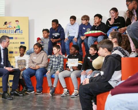 Kanzleramtsminister Thorsten Frei liest Kindern aus einem Buch in einer Berliner Grundschule vor.