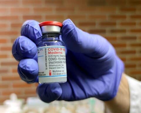 Moderna-Impfampulle symbolisiert Rückkehr zur Stabilität nach herausfordernden Jahren in der Impfstoffindustrie.