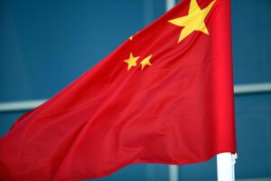 Fahne Chinas vor dem Hintergrund von Menschenrechtsverletzungen gegen Uiguren und Abschiebung.