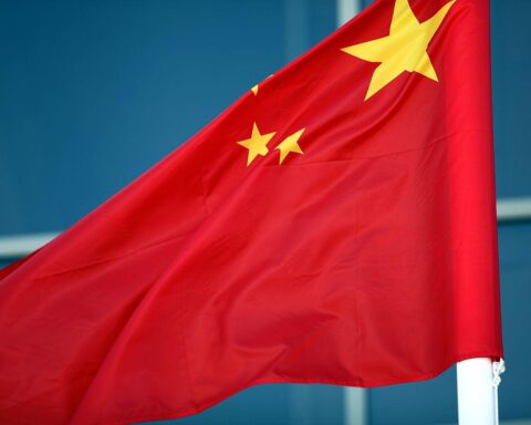 Fahne Chinas vor dem Hintergrund von Menschenrechtsverletzungen gegen Uiguren und Abschiebung.