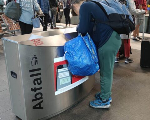 Eine Frau durchsucht einen Müllcontainer, Symbol für Altersarmut und soziale Ungerechtigkeit.