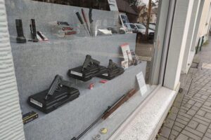 Waffenladenregal mit verschiedenen Waffen; Symbol für rechtliche Waffenerlaubnis und Extremismus.