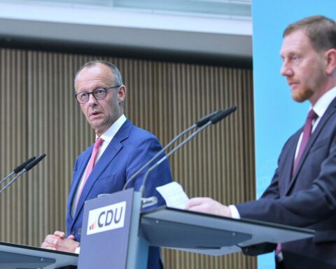 Politiker Merz und Kretschmer im Fokus kritischer Diskussion über russische Energielieferungen.