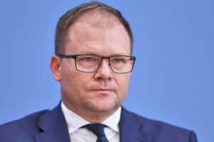 Carsten Schneider spricht zur Klimakonferenz, umgeben von internationalen Verhandlungsdelegierten.