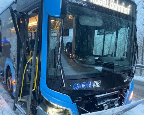 Ein beschädigter Schulbus auf einer winterlichen Straße, Polizei vor Ort, verunglückte Insassen.