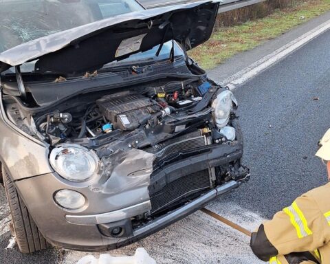 Zwei beschädigte Pkw, Feuerwehr im Einsatz, gesperrte Fahrspuren, Trümmerteile auf Autobahn, Verkehrsteilnehmer.