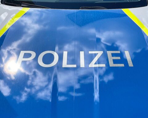 Grafik eines Verkehrsunfalls mit Polizei und Rettungsdiensten, sowie beschädigten Fahrzeugen im Vordergrund.