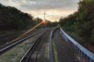 Ein Bahnhof mit Schienen und Warnhinweisen zur Sicherheit am Gleis.