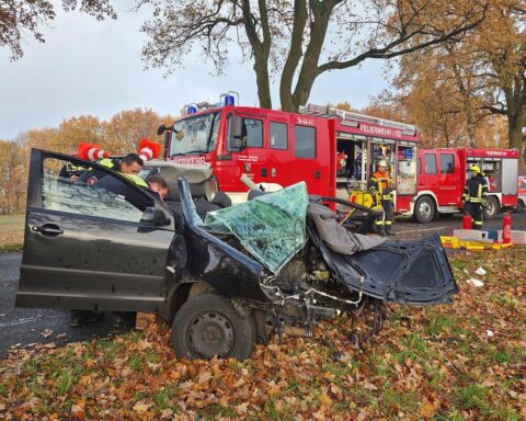 Verunfallter VW Polo, Unfallstelle, rettende Feuerwehrkräfte, abgeknickter Baum, Rettungswagen vor Ort.