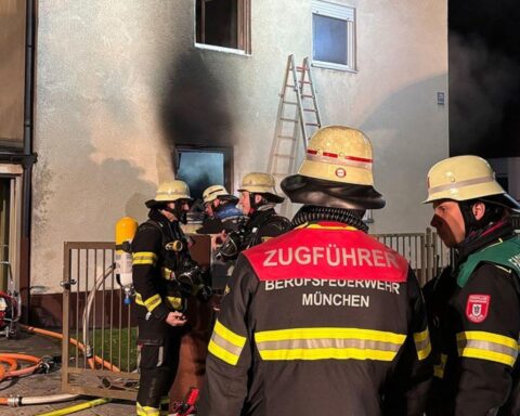 Feuerwehr München rettet Mann aus Mehrfamilienhausbrand, Einsatzkräfte mit Drehleiter im Einsatz.