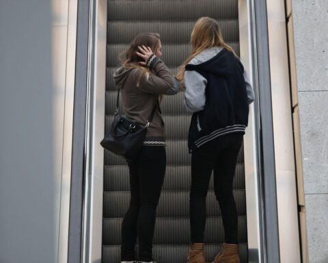 Junge Mädchen auf Rolltreppe, symbolisiert unsicheres Shopping-Umfeld und aktuelle Deliktsituation in Einkaufszentren.