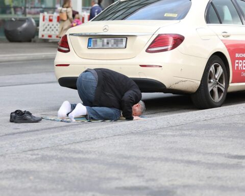 Muslimischer Taxifahrer betet auf Teppich, symbolisiert kulturelle Vielfalt und Toleranz in Europa.