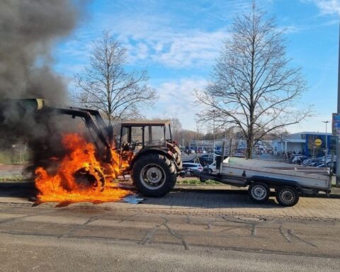Traktor in Flammen auf einer Straße, Feuerwehr gelöscht, keine Verletzten, Straße gesperrt.
