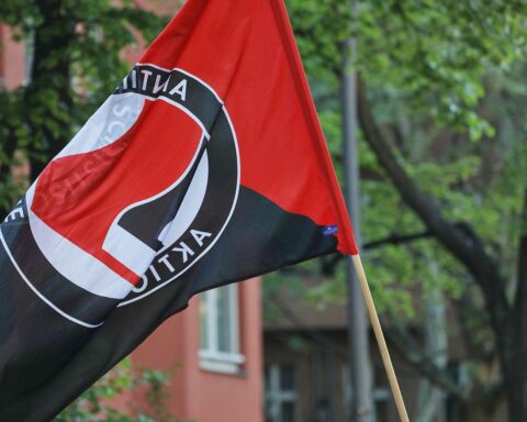 Antifa-Fahne vor US-Flagge, symbolisiert Einstufung als Terrororganisation durch USA.