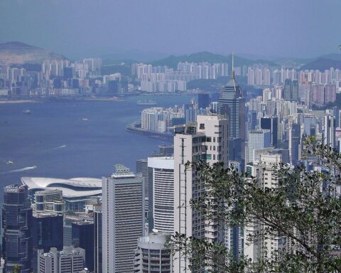 Dramatischer Blick auf Hongkong, während große Rauchwolken über brennenden Wohnblöcken sichtbar sind.