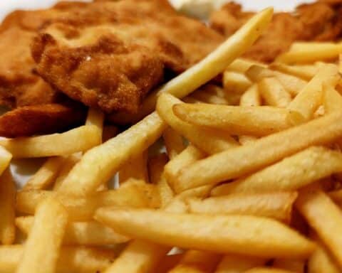 Pommes und Wiener Schnitzel, Symbol für traditionelle deutsche Küche und Verbrauchermeinung zu Alternativen.