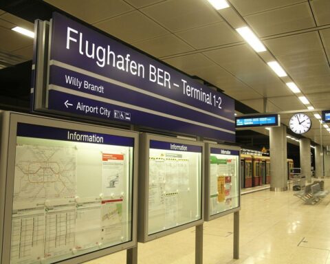 Flughafen BER mit Menschen und Flugzeugen; Symbol für steigenden Flugverkehr und umstrittene Steuerpolitik.