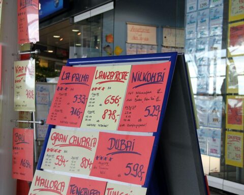 Flughafen und Flugzeuge mit Preisschildern, die sinkende Ticketpreise symbolisieren für Sommerurlaub 2026.