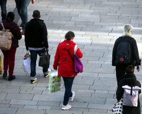 Menschen in einer Fußgängerzone reflektieren die stabilisierte Verbraucherstimmung in Deutschland.