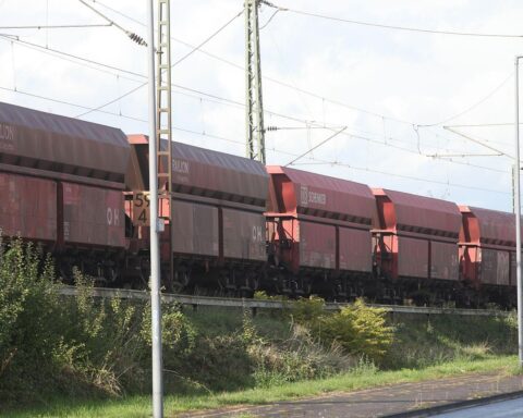 Güterzug auf Schienen, umgeben von Landschaft, symbolisiert den Straßenverkehrs- und Logistikbedarf.