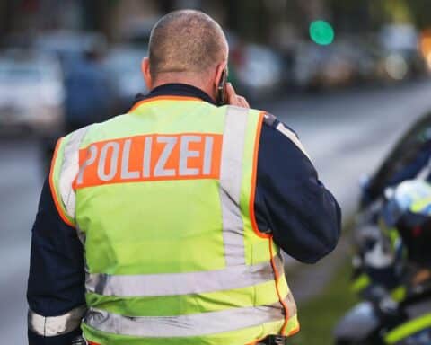 Verkehrsunfall zwischen Motorrad und Auto auf belebter Straße mit Polizei vor Ort.