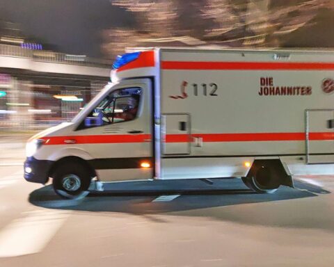 Rettungswagen bei nächtlichem Verkehrsunfall, Feuerwehr im Einsatz, verletzte Personen in Behandlung.