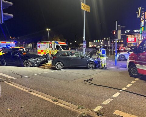 Verkehrsunfall mit zwei Fahrzeugen, Feuerwehr im Einsatz, gesperrte Straße, Verletzte, Betriebsstoffe.