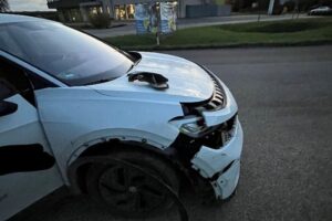 Kreisverkehr mit beschädigten Fahrzeugen nach Vorfahrtsmissachtung durch Fahrer. Polizei weist auf Regeln hin.