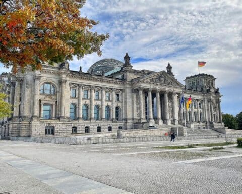 Klares Winterbild mit Schnee, Sonne und dem Reichstagsgebäude im Hintergrund.