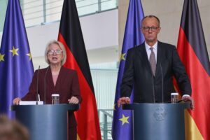 Monika Schnitzer übergibt Wirtschaftsbericht an Friedrich Merz; Diskussion über Investitionen und Wachstum.