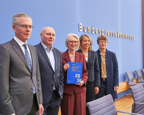 Ein Vortragsraum mit Experten, Diagrammen und Wirtschaftsdaten zur Konjunkturprognose in Deutschland.